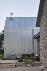Outdoor, Stone Patio, Porch, Deck, Shrubs, and Side Yard  Photos from A Limestone Cottage in Kansas Is Reborn With a Corrugated Steel Addition