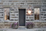 Exterior, Stone Siding Material, and House Building Type “1893” is engraved over the door on the original structure, commemorating the year it was built.  Photos from A Limestone Cottage in Kansas Is Reborn With a Corrugated Steel Addition