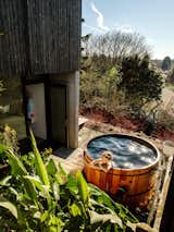 Outdoor, Trees, Shrubs, Wood Patio, Porch, Deck, and Hot Tub Pools, Tubs, Shower Jennifer requested the Japanese-style outdoor  soaking tub, but it’s enjoyed by the whole family. It was built by J&amp;K Cedar Works  for around $6,500.  Search “个税完税证明哪里打印专业办正加V信：(TTYY6590)” from A Darkened Cedar Dwelling in Portland Embodies “Less But Better” Design