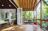Living Room, Wood Burning Fireplace, Rug Floor, Coffee Tables, Chair, Sofa, Medium Hardwood Floor, and Wall Lighting  Photos from This Lakeside Cabin in New York Is Offbeat in the Best Way