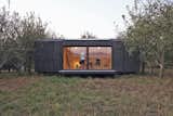 Heva is a tiny prefabricated cabin developed by Michel Hardoin, founder of Atelier 6 Architects. The exterior features pine plywood boards, which are charred for protection from insects and harsh weather. The structure is designed to open up to the outdoors with large glass doors, although each unit can be individually configured.