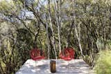 Chairs by Guilherme Wentz for Cremme sit on the deck.  Photo 7 of 9 in A Brazilian Couple’s Prefab Cabin Is the Perfect Outpost for Forest Bathing