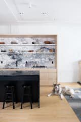Brandon Dean of Dean Works used two types of stone in the kitchen: a lighter, more active marble for the countertops and backsplash, and a tamer, dark soapstone for the kitchen island.