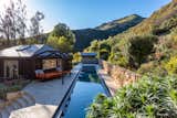 Outdoor, Trees, Back Yard, Stone Fences, Wall, Large Patio, Porch, Deck, and Large Pools, Tubs, Shower Featuring a gym/pool house and gorgeous grassy lawns, the spectacular estate also includes not one, but two ocean-view pools.  Photos from Mel Gibson Lists His Extravagant Malibu Mansion For $14.5M
