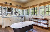 Bath Room, Wall Lighting, Medium Hardwood Floor, Freestanding Tub, and Drop In Sink A look at one of the five bathrooms.  Photos from Mel Gibson Lists His Extravagant Malibu Mansion For $14.5M