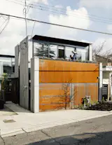 Rusting steel alternates with Öko Skin fiber-reinforced concrete panels on the laneway house facade.