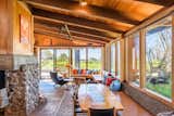 Living Room, Chair, Floor Lighting, Track Lighting, and Bench The great room wraps frames sweeping views of the open meadow and ocean beyond, while also providing comfortable sitting areas and dining spaces.  Photo 4 of 15 in A Sea Ranch Stunner With a Green Roof Asks $1.3M