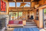 Living Room, Sofa, Stools, Table Lighting, Chair, Standard Layout Fireplace, Rug Floor, and Track Lighting Expansive glazing allows gorgeous natural light to flood throughout.  Photo 5 of 15 in A Sea Ranch Stunner With a Green Roof Asks $1.3M