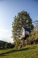 Framing picturesque views of a small valley and nearby orchard, Baumhaus Halden is comprised of a steel frame with four wooden support beams.