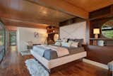 The master suite is a restful retreat, featuring an extensive window wall as well as beautifully restored hardwood and original paneling.