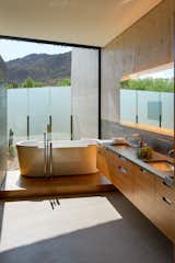 A floor-to-ceiling window in the bathroom frames mesmerizing mountain views.