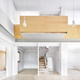 Living Room, Terrazzo Floor, and Pendant Lighting Since Josep and Encarna wanted to live on a single level, Tapias removed part of the mas’s second floor to create a double-height space. Pendants by Faro Barcelona hang near the balcony Mas. The ground floor, designed to be flexible, currently holds offices for the couple, a library, a living room, and a piano for their teenage daughter. The terrazzo floors are original to the house.  Photo 10 of 15 in A House in Catalonia Comes Together Like a Collage