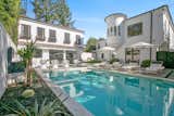 Outdoor, Trees, Concrete, Pavers, Shrubs, Back Yard, Raised Planters, and Large Near the pool is a detached guesthouse, which features a kitchen, dining area, and living room.  Outdoor Concrete Raised Planters Shrubs Photos from Beck’s Former Mediterranean-Style Retreat Lists For $8M