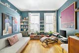 Living Room, Shelves, Media Cabinet, Recliner, Medium Hardwood Floor, Sofa, and Wall Lighting  Photos from Snag This Chic Micro-Flat in Brooklyn For $339K