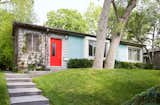 Sitting alongside five other Lustron homes on Nicollet Avenue in Minneapolis, this rare prefab is cladded in sleek, "surf-blue" steel panels. A bright red door welcomes guests inside.