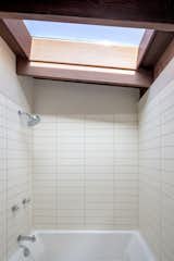 A large skylight above the shower ushers in ample natural light into the bathroom.