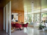 Executive armchairs by Eero Saarinen for Knoll surround an Edward Wormley table for Dunbar in the dining area. The chandelier is vintage.