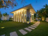 Custom landscape lighting illuminates the home's architectural features at night.