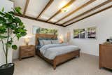 The wood-beamed ceilings continue into the bedrooms, which overlook the quiet yard. New carpeting adds a fresh feeling to the spaces.
