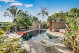 The resort-like backyard features a solar-heated pool surrounded by a large flagstone patio. Closer to the house, a more intimate garden area includes a mosaic-tiled outdoor shower.