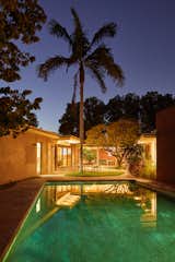 The backyard patio and pool glow in the moonlight, recalling a feeling of glory days from the retro Googie era.