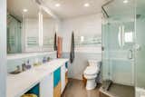 One of three bathrooms, the updated master bath features the same plywood and maple cabinetry as in the kitchen. Colorful accents and modern features complement the space.