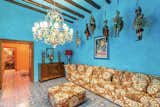 The formal sitting area is painted in a striking shade of sky blue. Antiques line the walls and hang from the timber-beamed ceilings, while a different majolica tile motif covers the floor.