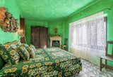 Lace curtains line the large windows of this emerald green suite, which also features an antique fireplace and furnishings.