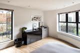 The bright master bedroom provides access to a private rooftop terrace. A large window stretches along a semicircular wall overlooking the backyard.