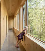A narrow corridor connects a row of bedrooms, bathrooms, and laundry.