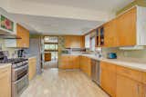 The large kitchen offers cabinetry galore and modern appliances. Light hardwood floors complement the  Photo 6 of 14 in This Quirky Abode Built By a Frank Lloyd Wright Apprentice Wants $575K