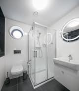 The full bathroom offers enough space and storage, with a porthole window above the loo.