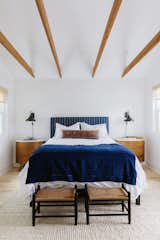 Wooden beams delicately span a gabled ceiling in the guest bedroom.