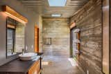 Inside the bunkers, each one serves a different purpose, with some used as storage and others used as private living ares. Here, this bathroom features simple finishes of local wood, with skylights overhead to brighten the space.