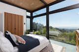 The guest bedroom offers an impressive view. Expansive clerestory and picture windows from Western Window Systems complete the floor-to-ceiling effect.