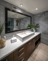 A look at the master bathroom, which has a spa-like feel to it. Wooden tones blends with grey tile work in the space.