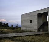 Architects Javier Sánchez and Carlos Mar of JSa created a bold house in Valle de Bravo that emerges from the setting in three parts like "excavated stone boxes." Valle de Bravo that emerges from the setting in three parts like "excavated stone boxes. Inspired by Donald Judd’s minimalist works, the three volumes feature board-formed concrete walls accented with charred wood. Strategically placed cutouts and windows frame views within and between the volumes and out to the surrounding terrain.