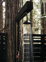 Molly and Jeff wanted their guests to have creature comforts, so early on they built an outdoor shower that’s illuminated by string lights at night.