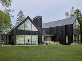 Although synthetic slate roof tiles have been around since the 1970s, the way architect Stephen Bruns used them to completely clad Woven House is unusual. "I love this material," says Bruns. "The way light reflects off the tiles creates a specular effect, almost like a mosaic." That reflective quality is enhanced by the floor-to-ceiling windows by Loewen.