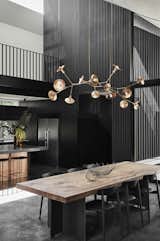 For the dining room, Splinter Society designed a table with a top made of mango timber, reclaimed from Mossman Gorge in northern Queensland, Australia, and a steel base. The light fixture above is a custom piece by Giffin Design, and the centerpiece sculpture is by Emma Davies.