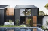 The native plantings in the courtyard, which is enclosed by a wall for privacy in the suburban setting, visually link it to the established eucalyptus trees at the front and rear of the property. The home’s dark cladding is accented by rose gold stainless steel panels.