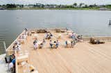 A public sun deck made of slatted wood is the perfect setting for a waterfront meal or conversation.&nbsp;