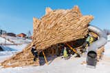 A structure of flowing, trimmed logs shelters a playground for children.&nbsp;