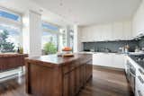 An Italian-designed kitchen is discretely hidden behind the dining area. Outfitted for entertaining, a large butcher block island sits in the middle of the space, surrounded by two ovens, a Miele six-burner cooktop, and a Sub-Zero refrigerator. There is also direct access to an outdoor kitchen with built-in grill and preparation area.