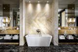 The Bisha Suite bathroom features a large shower, tub, and two vanities—all wrapped in golden spider marble.
