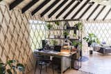 "It's really nice to have a little office space that I can call my own," says Zach. A vintage tanker desk abuts two Archive walnut bookcases from Article. A Modway Entangled Dining Arm Chair echoes the open lattice of the yurt.