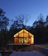 Like a lantern in the night, the cabin glows in its wooden setting once the sun goes down.