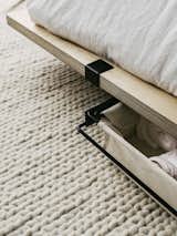 An under-bed storage caddy provides a place for linens.