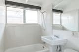Similar to the rest of the property, the bathroom boasts a clean, crisp white palette, and is well lit thanks to the sliding horizontal window above the shower/tub.