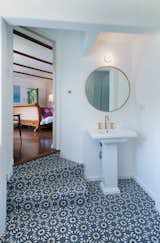 Striking blue tiles line the floors in the adjoining bathroom. 